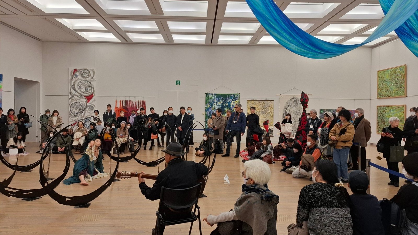 日本第二十三《NAU21世紀美術連立展》-東京國立新美術館展覽-參觀者仔細瀏覽台灣參展者作品、現場並有表演藝術家、音樂藝術家共同演奏