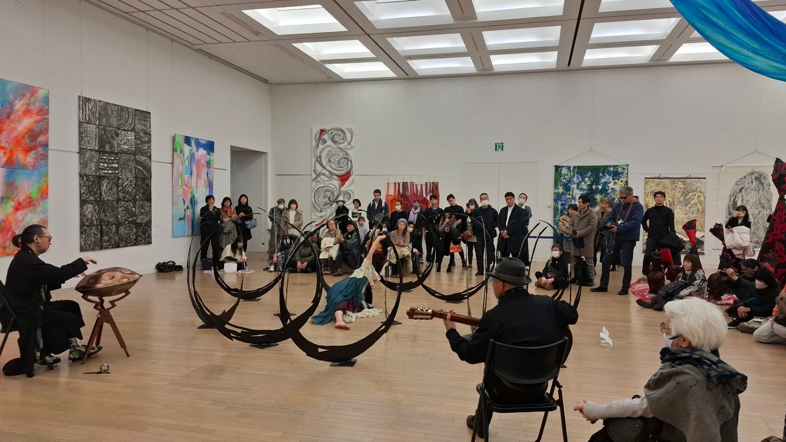 日本第二十三《NAU21世紀美術連立展》-東京國立新美術館展覽-參觀者仔細瀏覽台灣參展者作品、現場並有表演藝術家、音樂藝術家共同演奏