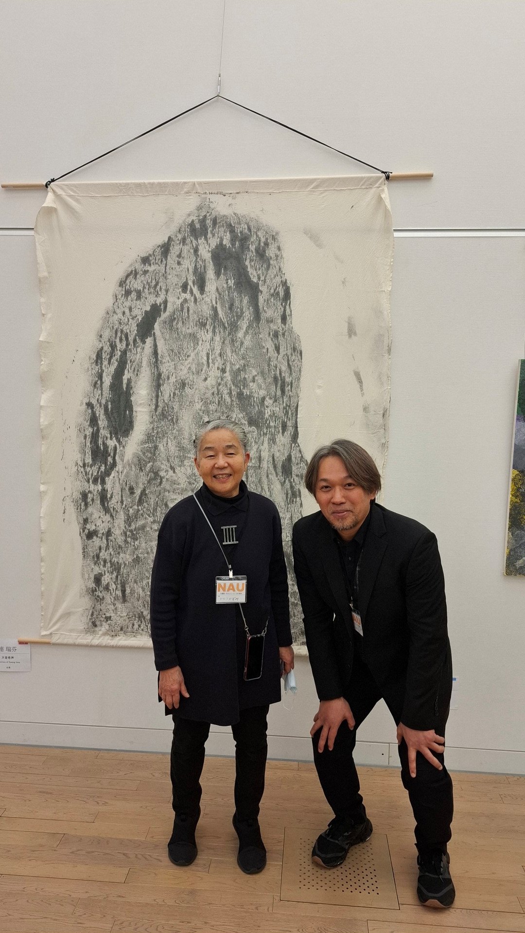 日本第二十三《NAU21世紀美術連立展》-東京國立新美術館展覽-ichonokigallery社長、藝術家 加藤和美女士與台灣參展者 王穆提先生(日本NAU21世紀美術連立展成員)於台灣參展者 王穆提先生作品前合影。